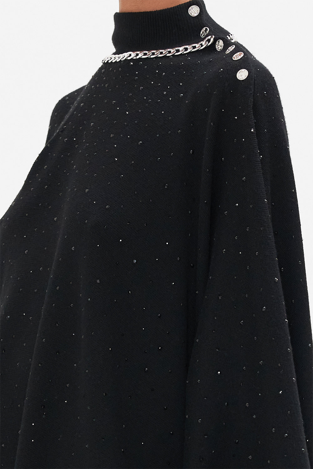 Detail view of model wearing CAMILLA black knit poncho in Chaos Magic