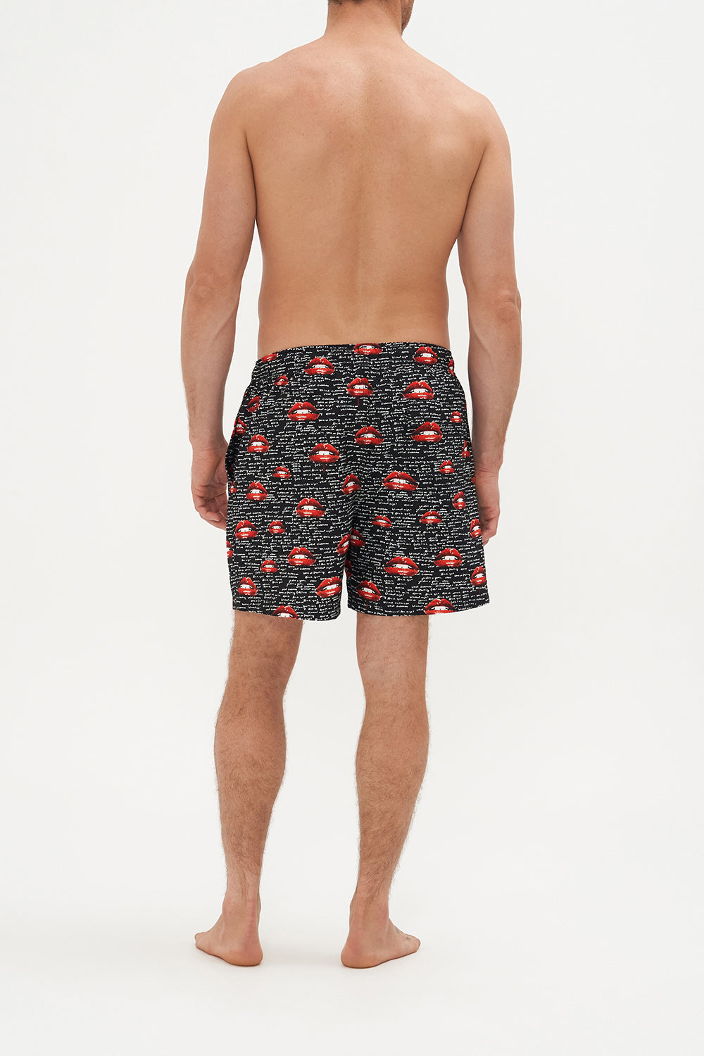 Back view of model wearing Hotel Franks by CAMILLA mens elastic waist boardshorts in black Chaos Magic Print