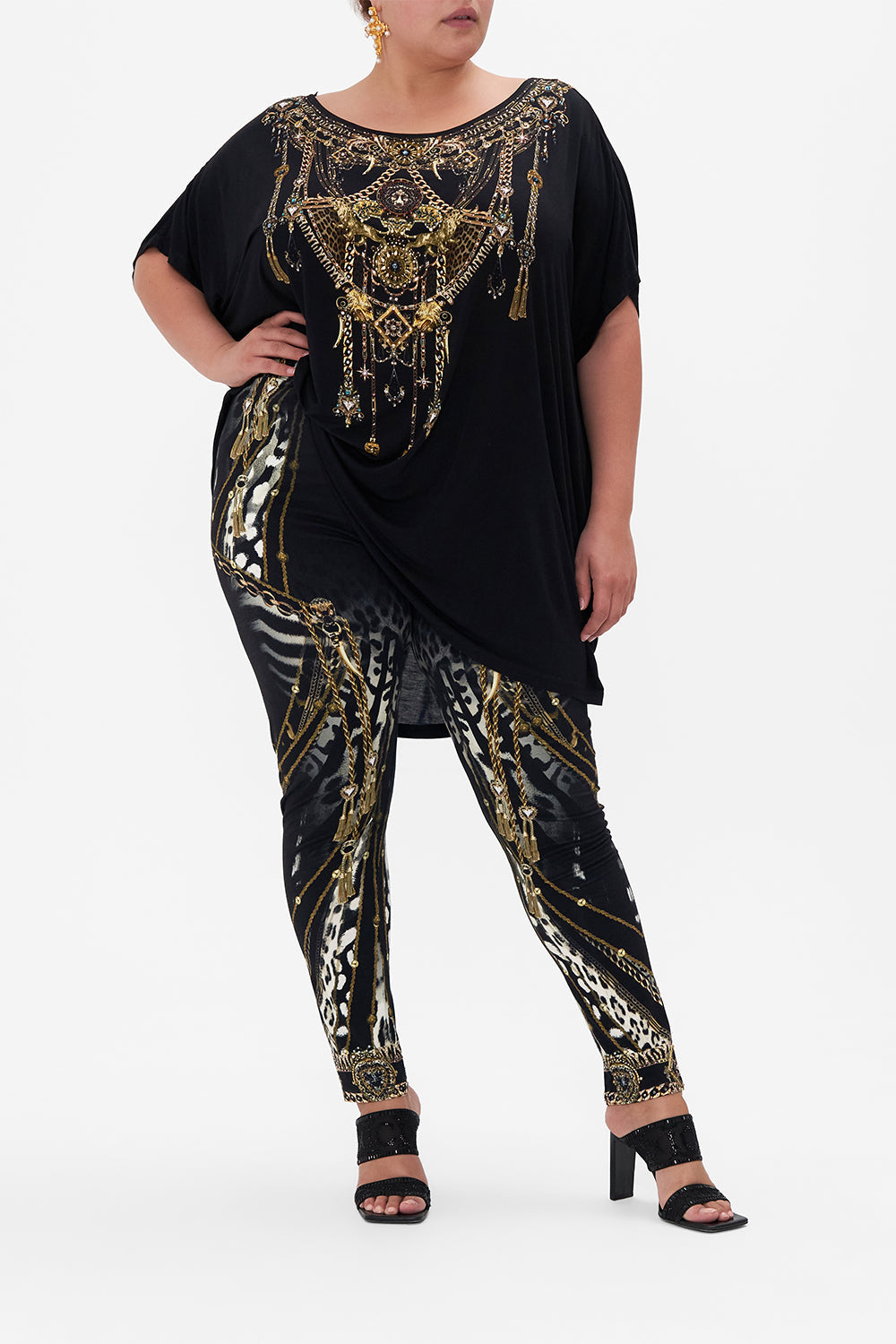 Front view of curvy model wearing CAMILLA plus size black leggings in Untamed Royalty print