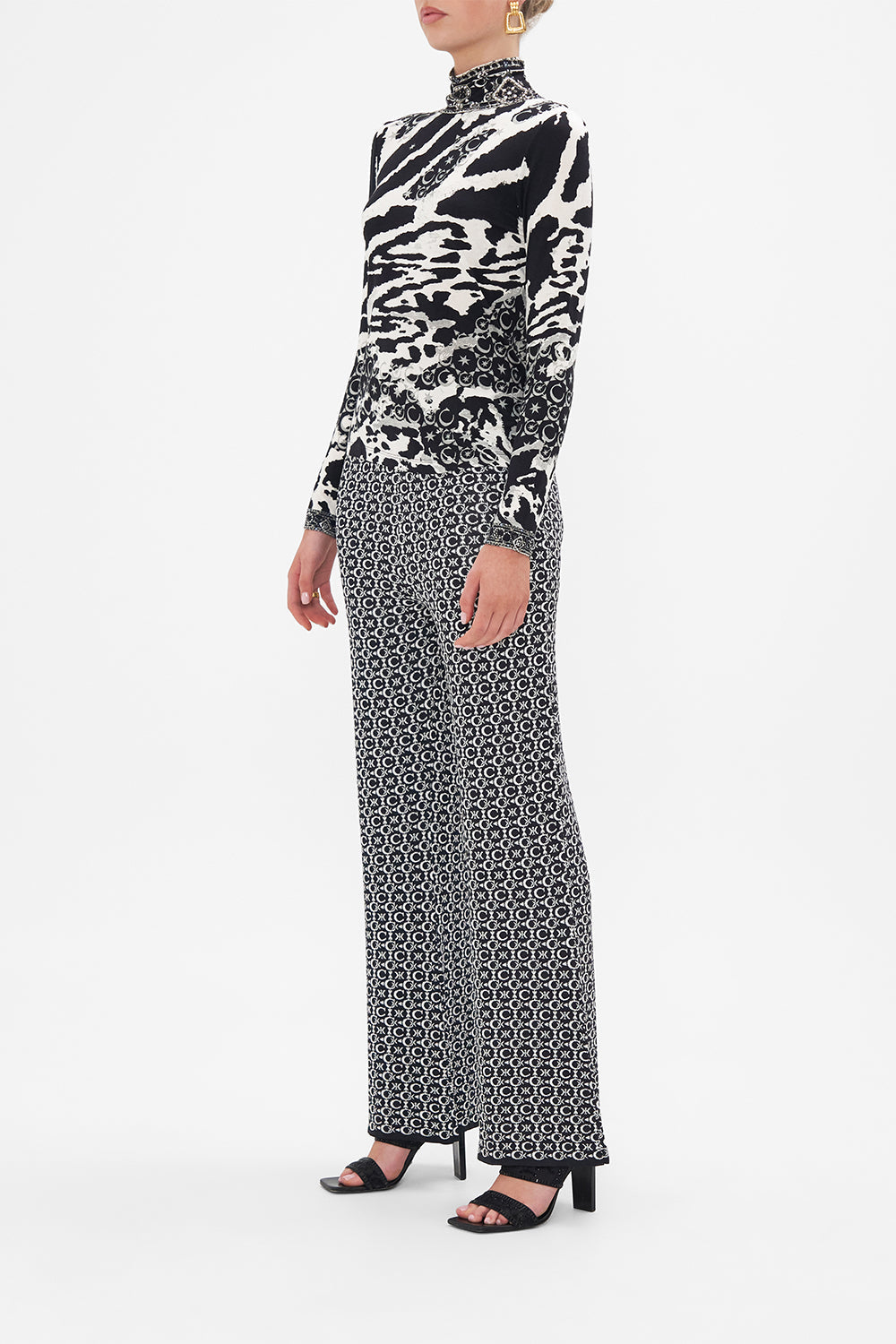 Side view of model wearing CAMILLA turtleneck top in black and white Feline Fantasy print
