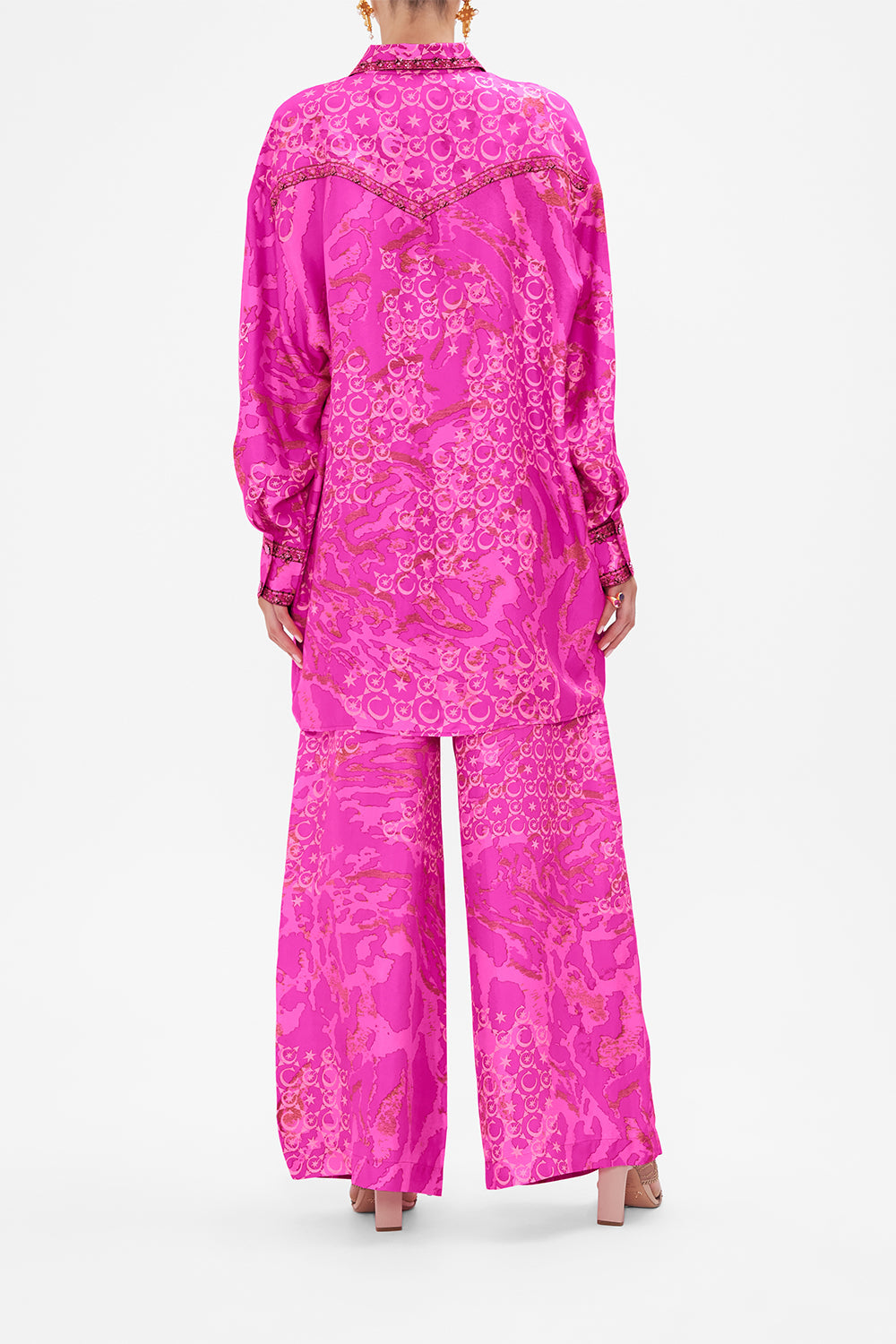 Back view of model wearing CAMILLA silk shirt in neon Song Of Sacrifice print