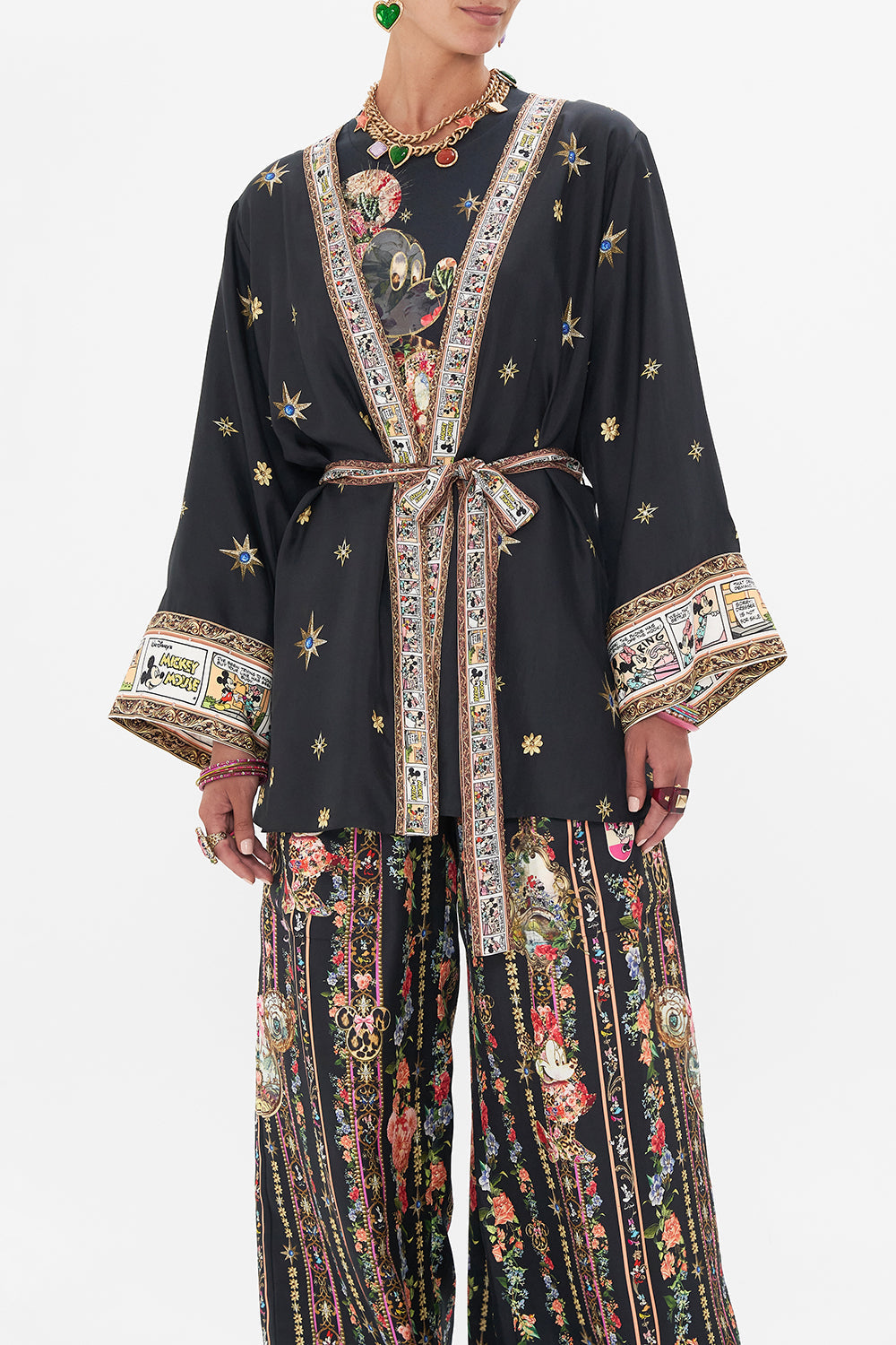 Crop view of model wearing Disney x CAMILLA short silk kimono at Midnght At Minnies print