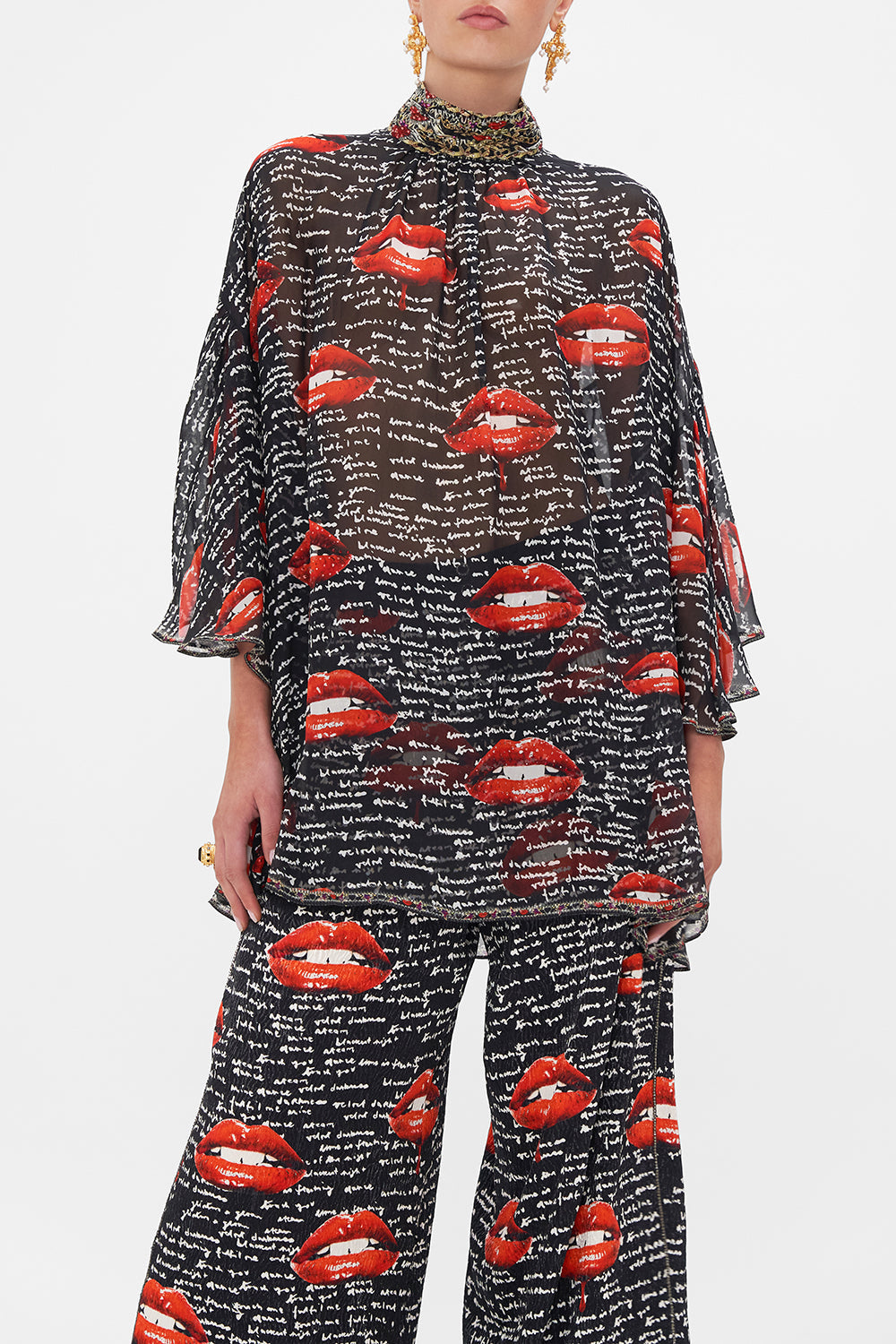 Crop view of model wearing CAMILLA black silk blouse in Chaos Magic print 