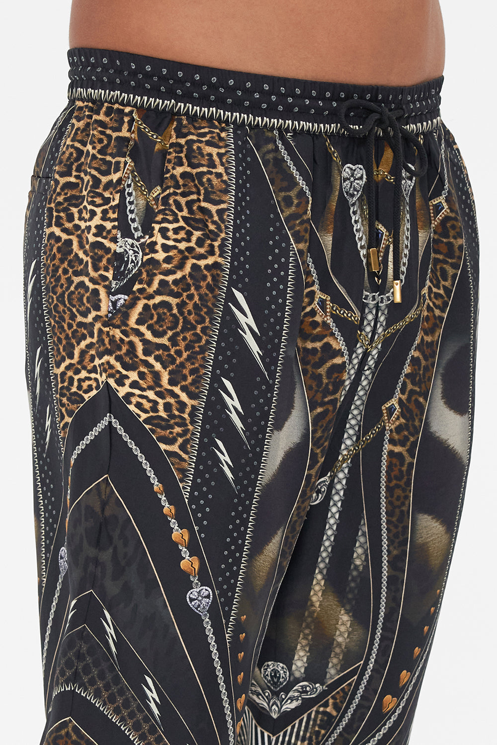 Detail view of model wearing Hotel Franks by CAMILLA mens pants in Chaos In The Cosmos animal print 