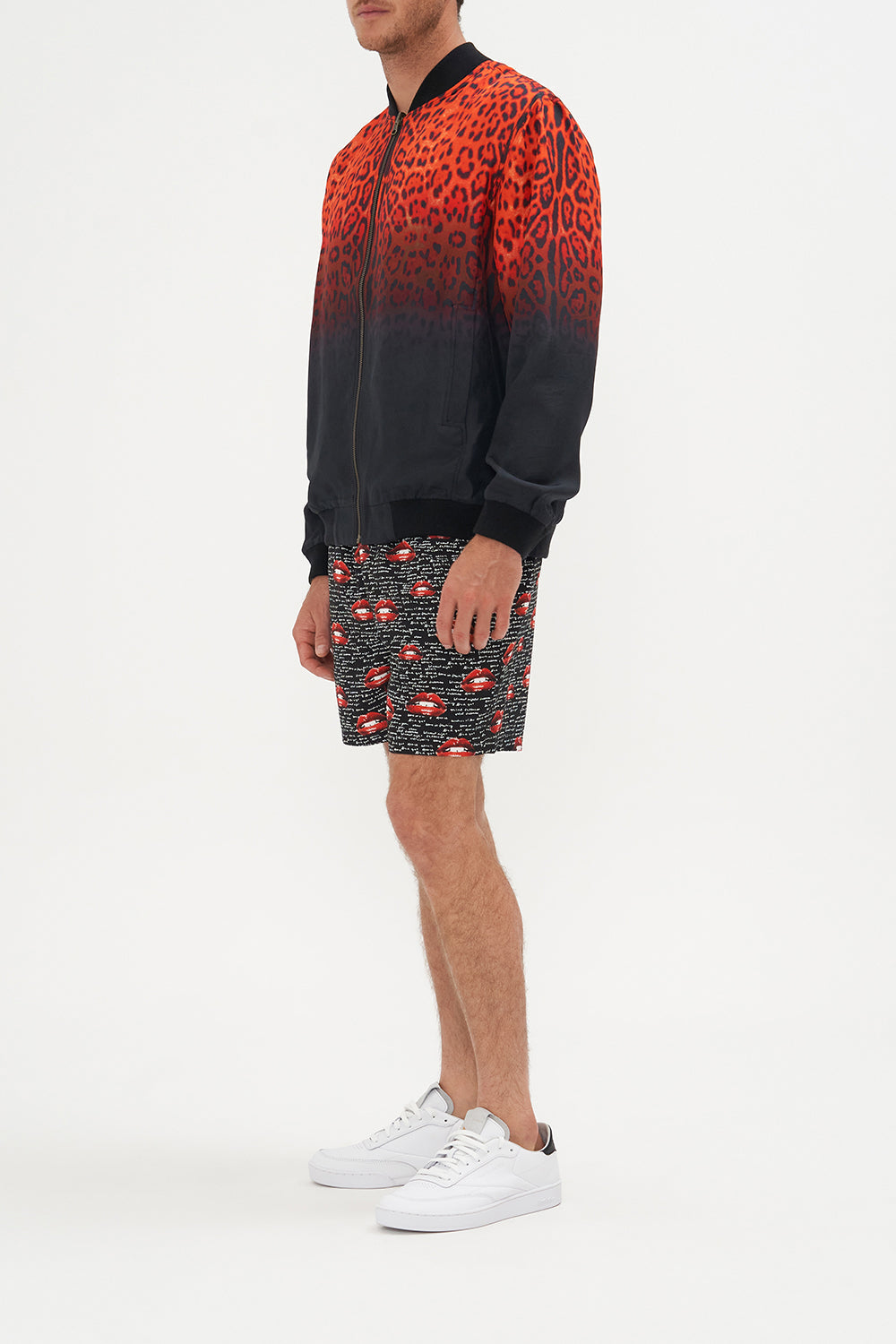 Side view of model wearing Hotel Franks by CAMILLA mens reversible bomber jacket in black and red Chaos Magic print 