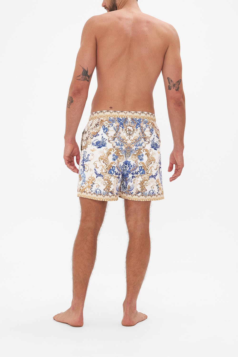 Back view of model wearing Hotel Franks by CAMILLA mens white boardshorts in Soul Searching print