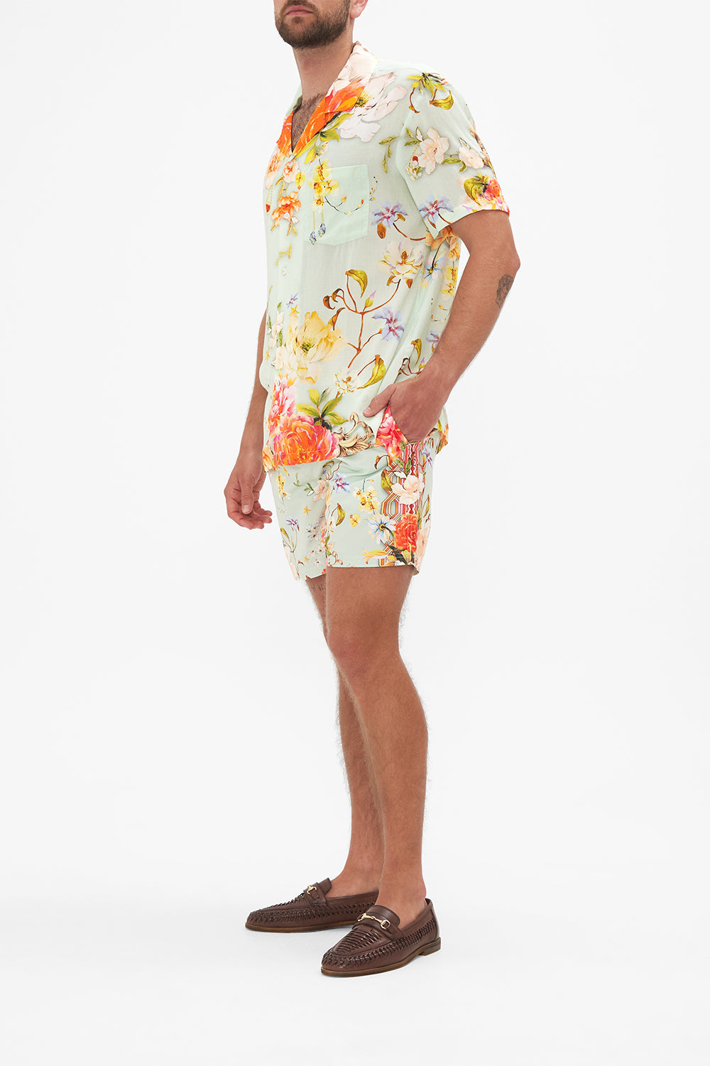 Side view of model wearing Hotel Franks by CAMILLA mens floral short sleeved camp collared shirt in Talk The Walk print