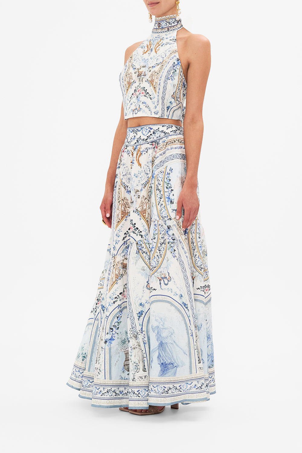 Side view of model wearing CAMILLA designer halter top in Season of The Siren print 