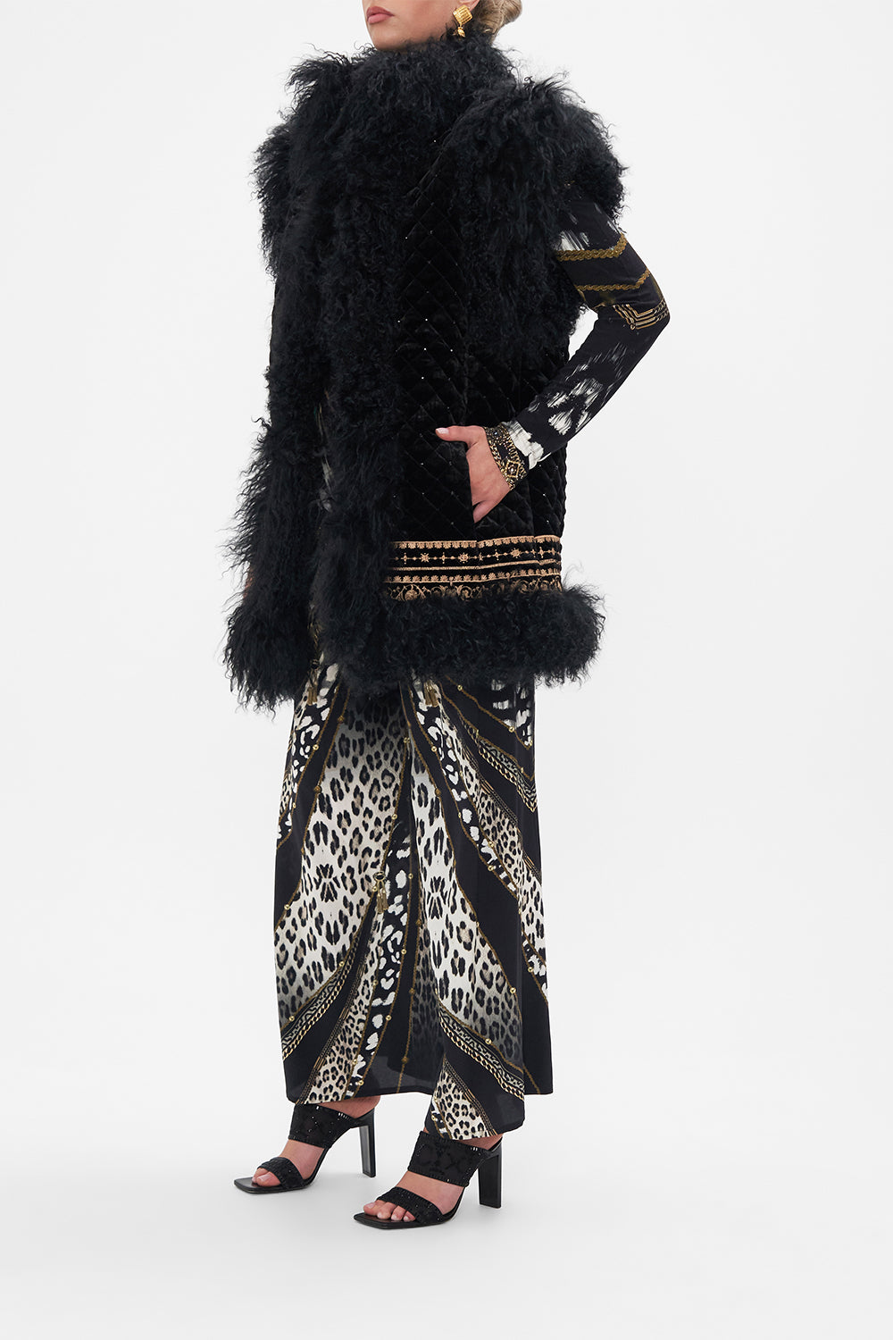Side view of model wearing CAMILLA black fur vest in Untamed Royalty print