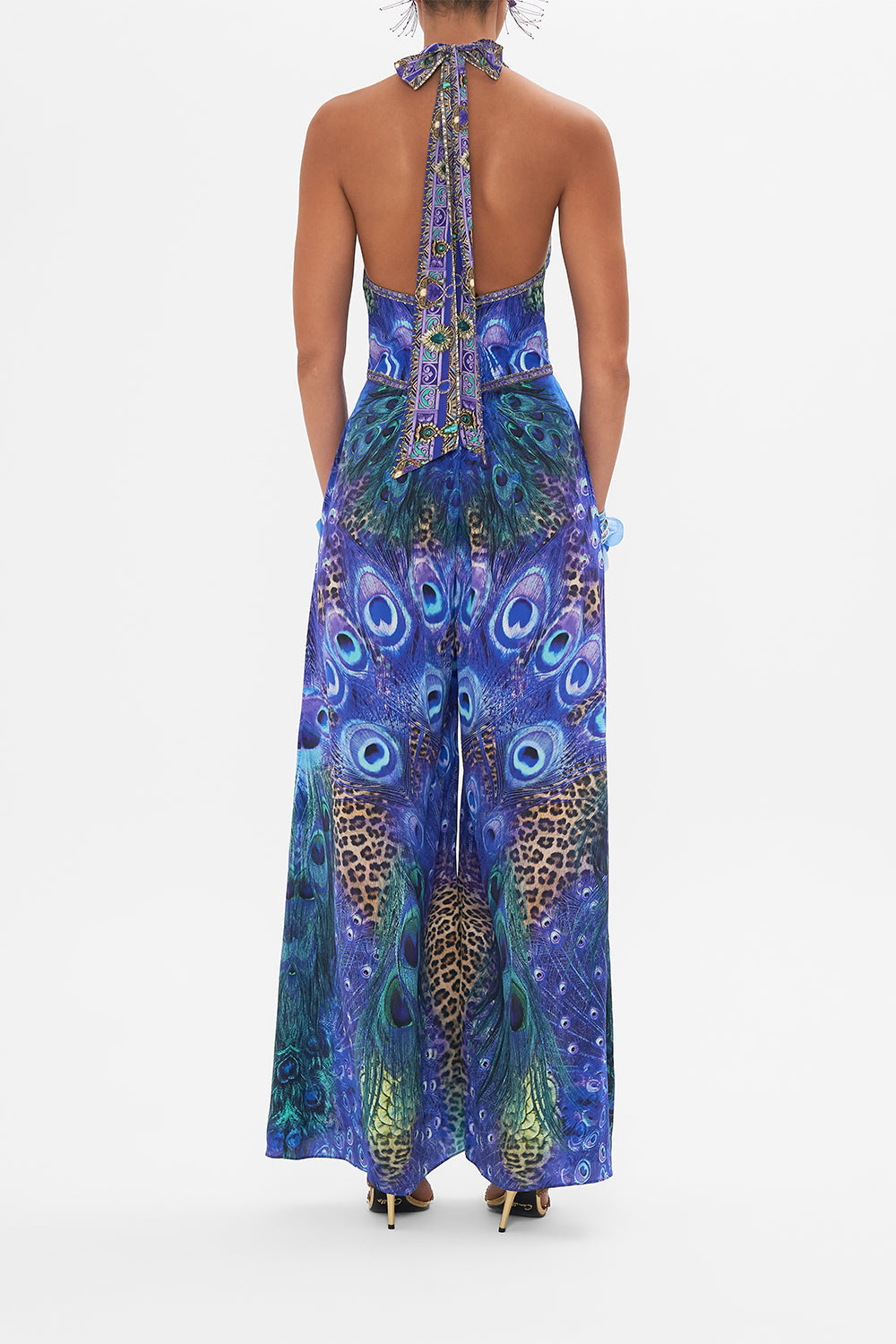Back view of model wearing CAMILLA silk jumpsuit in Peacock Rock print