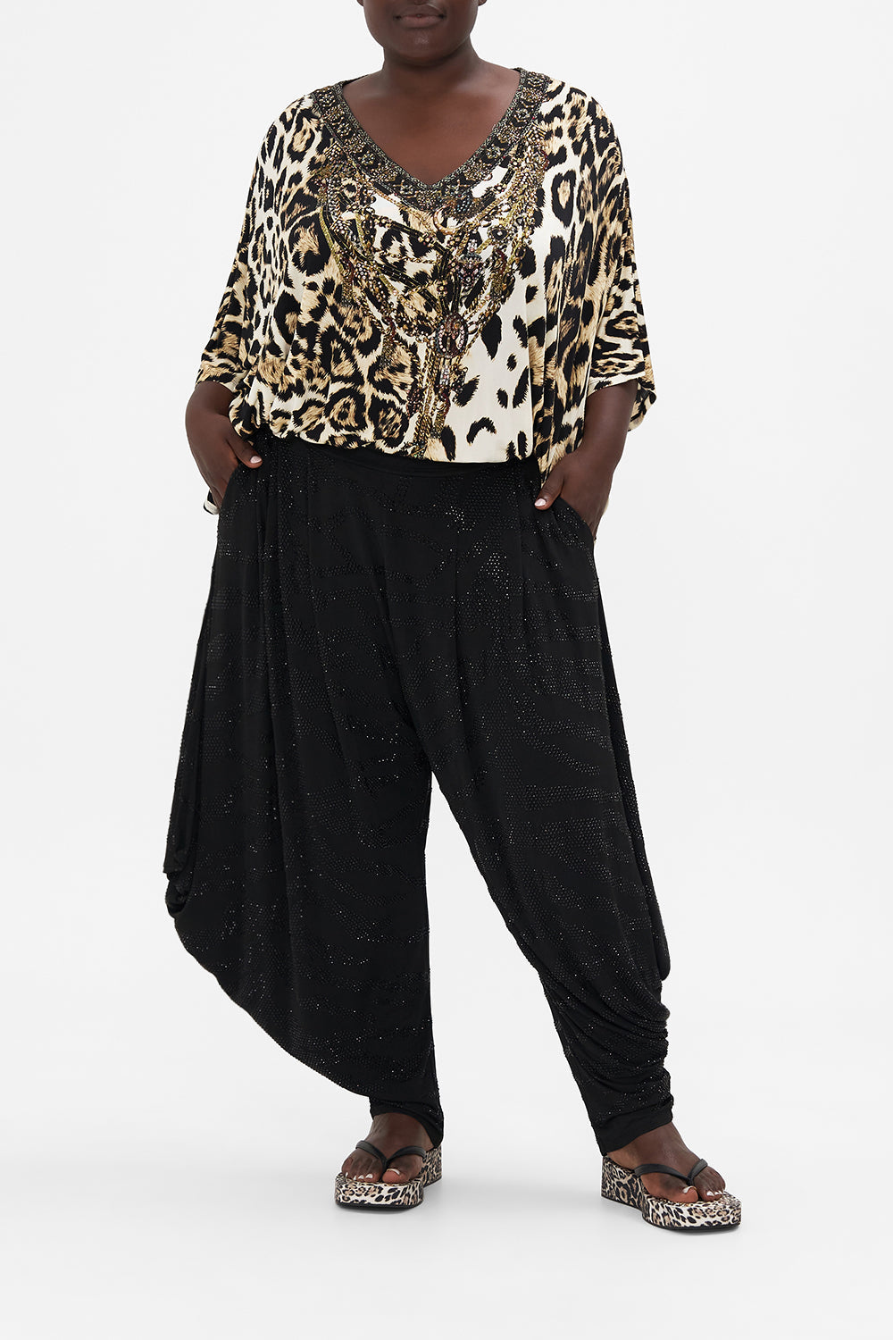 Front view of curvy model wearing CAMILLA plus size Black jersey drape pants in Tame My Tiger story